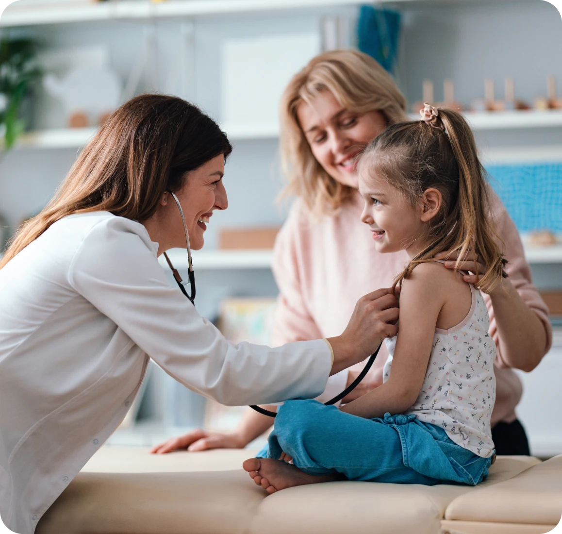 Doctor examining smiling child with stethoscope.