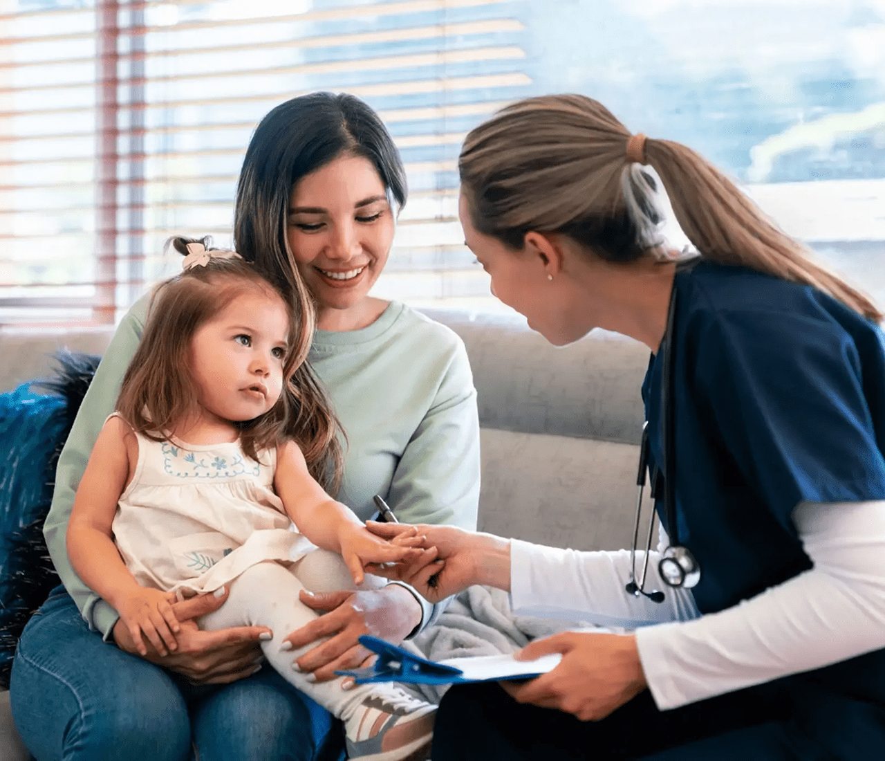 A doctor consulting a mother and her child in a bright clinic.